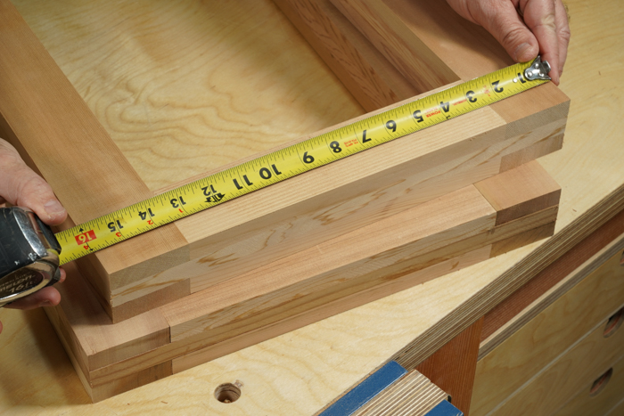 The author is measureing the width of the outdoor table legs. Right at sixteen inches. 