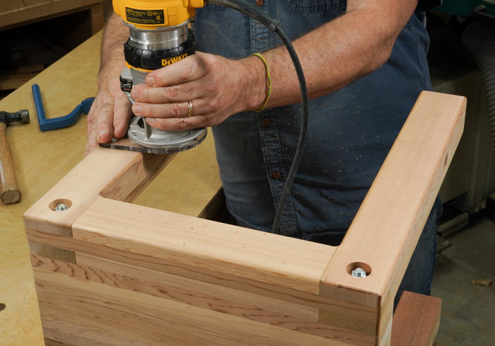 Using a small hand-held router to round off the edges of the table. 