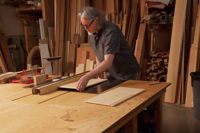 The author carefully lowers a piece on the table saw
