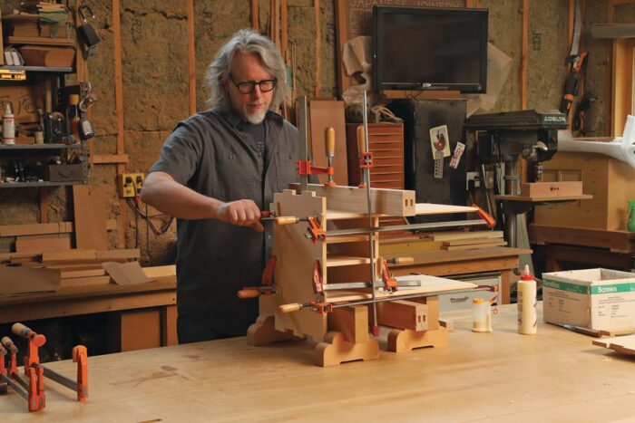 The author is gluing pieces together with lots of clamps