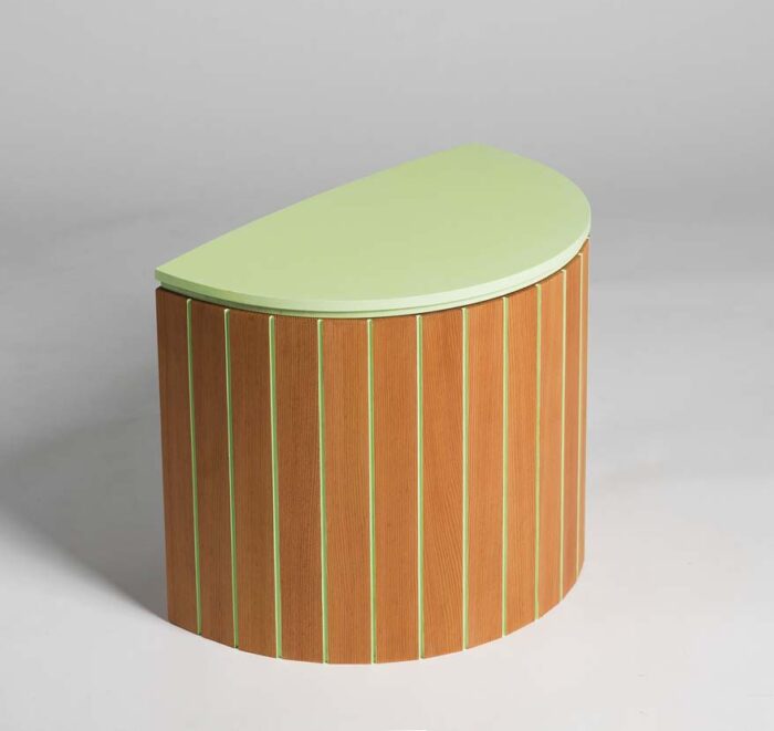 A half circle shaped, slatted stool made of cherry and painted with mint green paint on the seat and between slats. 