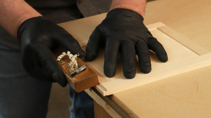 The author handplanes the notch that will eventually allow the door to slide into a groove in the tansu.