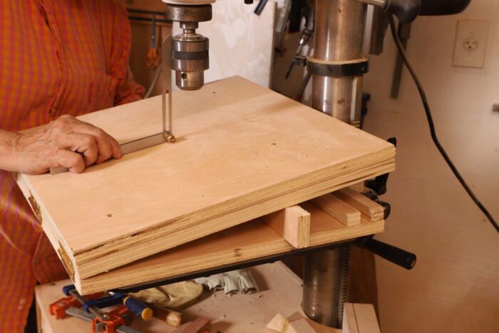 beth holds a bevel guage against the quill of the drill press to find the proper angle for the drill press jig. 