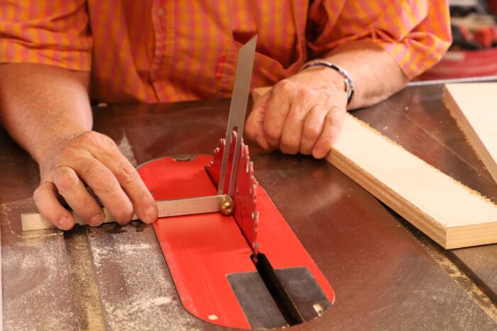 Beth uses the bevel gauge to tilt the blade on the table saw to the appropriate angle to rip the spacer. 