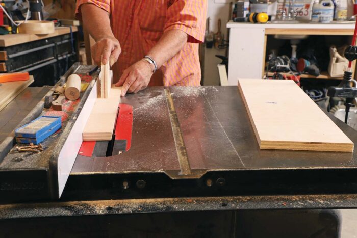 Beth rips a strip of plywood on the table saw.