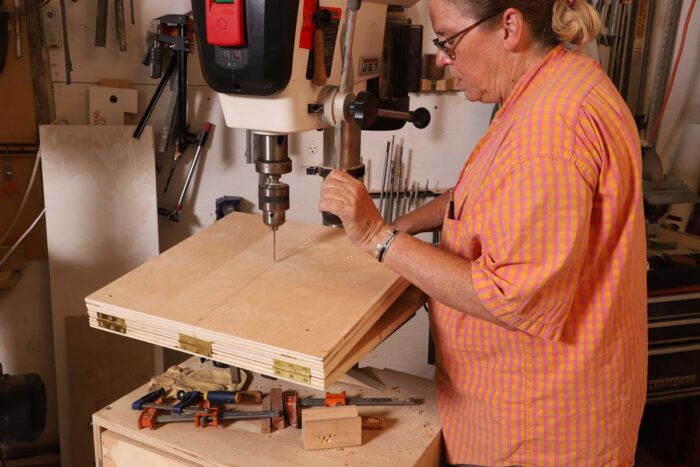 Beth adjusts the height of the drill press table. 