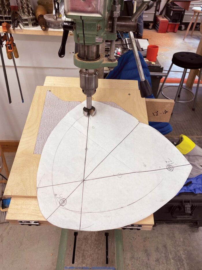 A paper template with lines drawn over the location of the holes, to line the seat up properly on the angled drill press jig. 