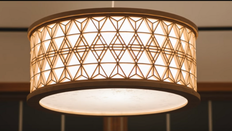 A round kumiko lamp illuminates a room with soft white light.