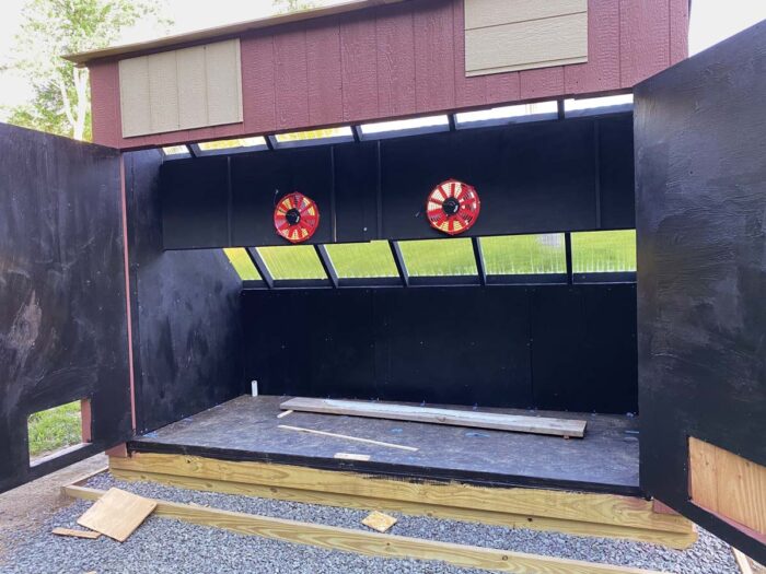 The doors of the kiln are open showing a black painted surface inside. 