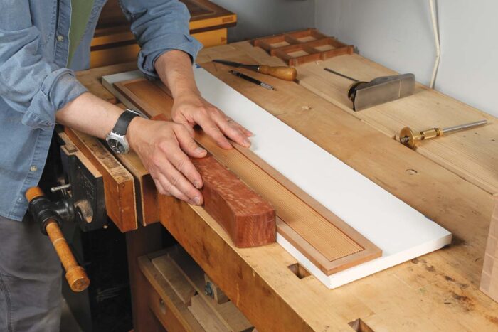 The author uses a hand plane to trim the back of the frame and panel.