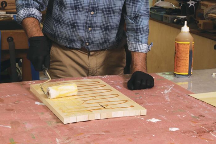 Tim applies polyurethane glue to the staves, using a small paint roller. 