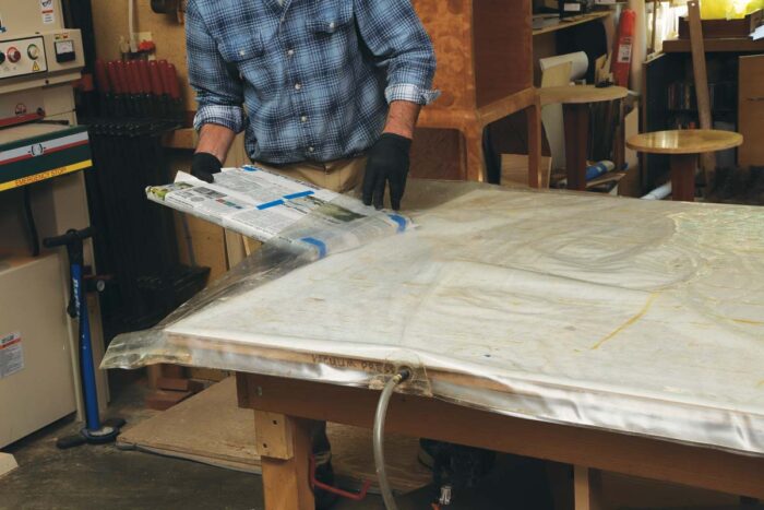 Tim slides the wrapped lumber core assembly into a veneer bag.