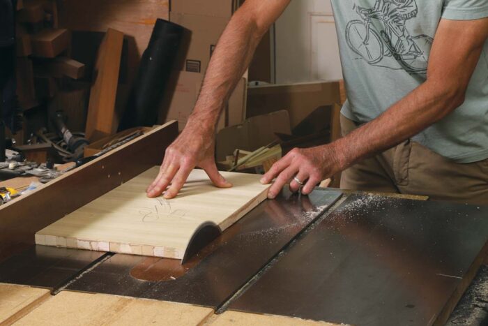 Tim rips the lumber core panel on the table saw, with the jointed edge against the fence.