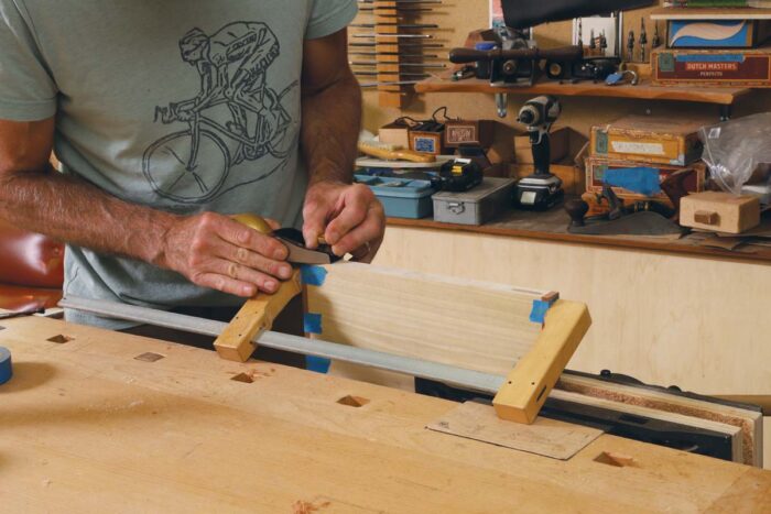 TIm uses a block plane to flush the overlap of edge banding to the rest of the lumbercore panel.