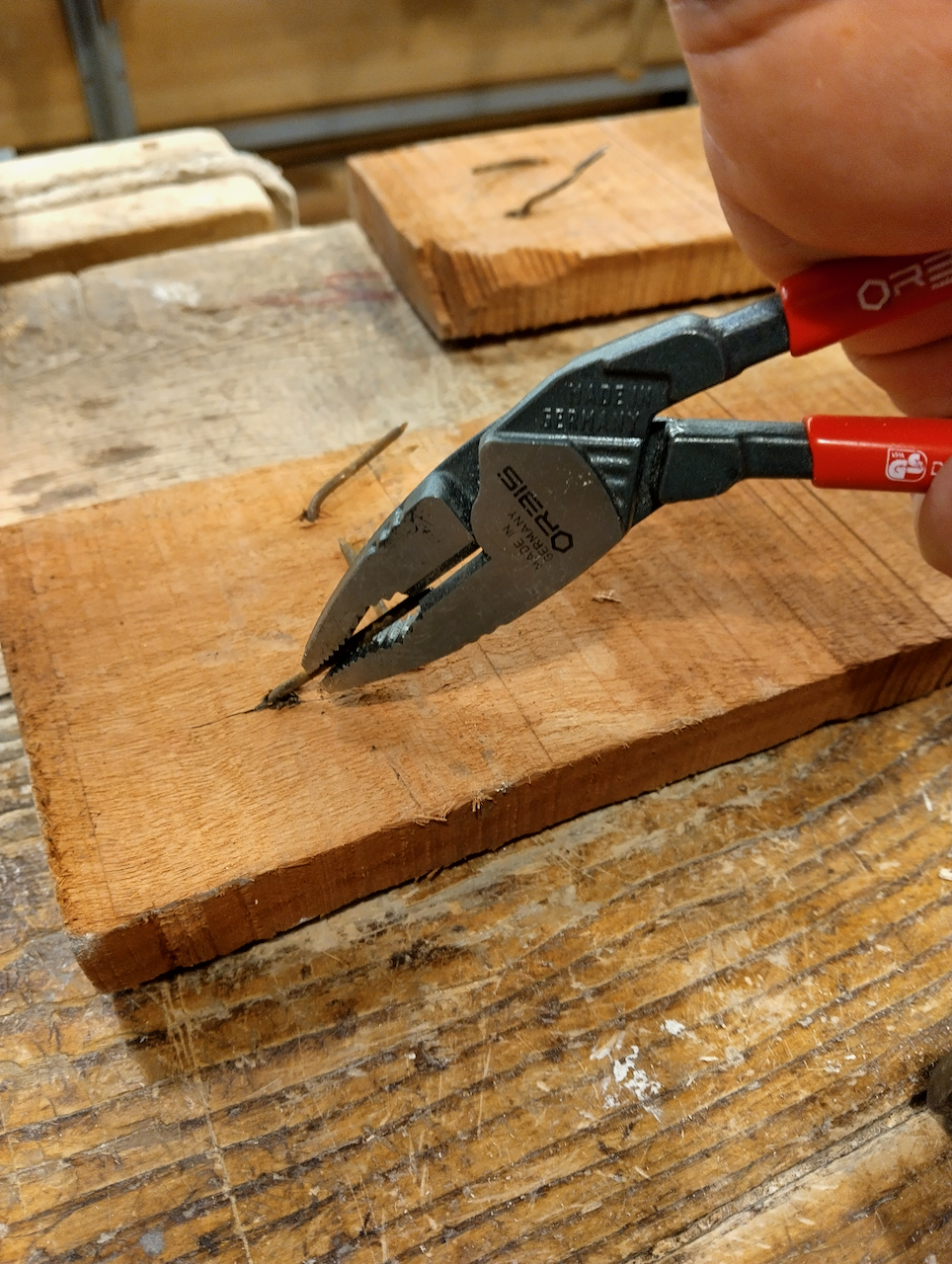 Yoav uses pliers to straighten a rusty nail.