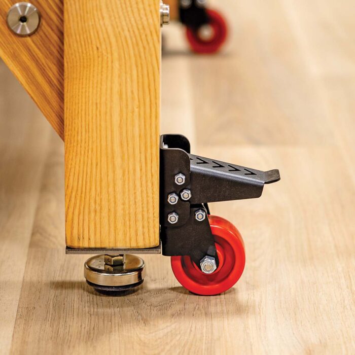 A caster with a rubber red wheel and a mechanism that lifts it using your foot. 