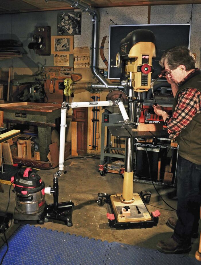 Roland uses the mullet boom arm to collect dust at his drill press