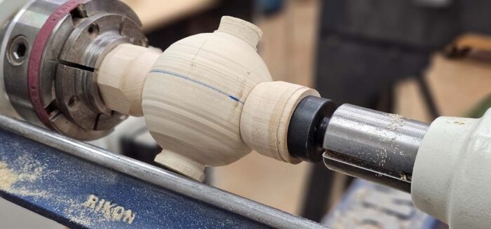 The ball is flipped and the ends that were held in the chuck are now perpendicular to the lathe