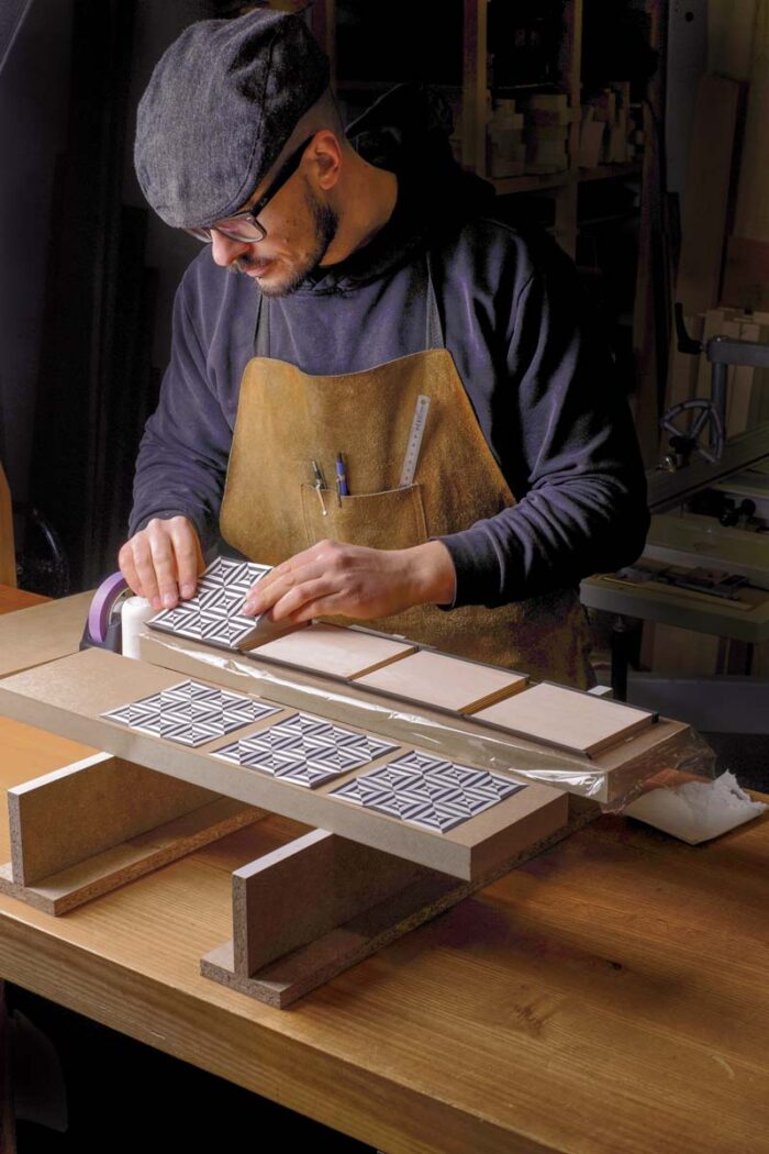 Vasko lays down the patterned veneer into premade baltic birch sides. 