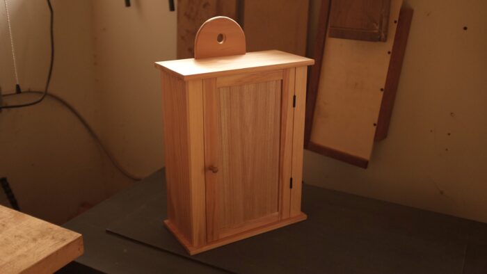 Another photo of a wall hanging cabinet, with the cabinet framed in the center of the photo and background more out of focus. 