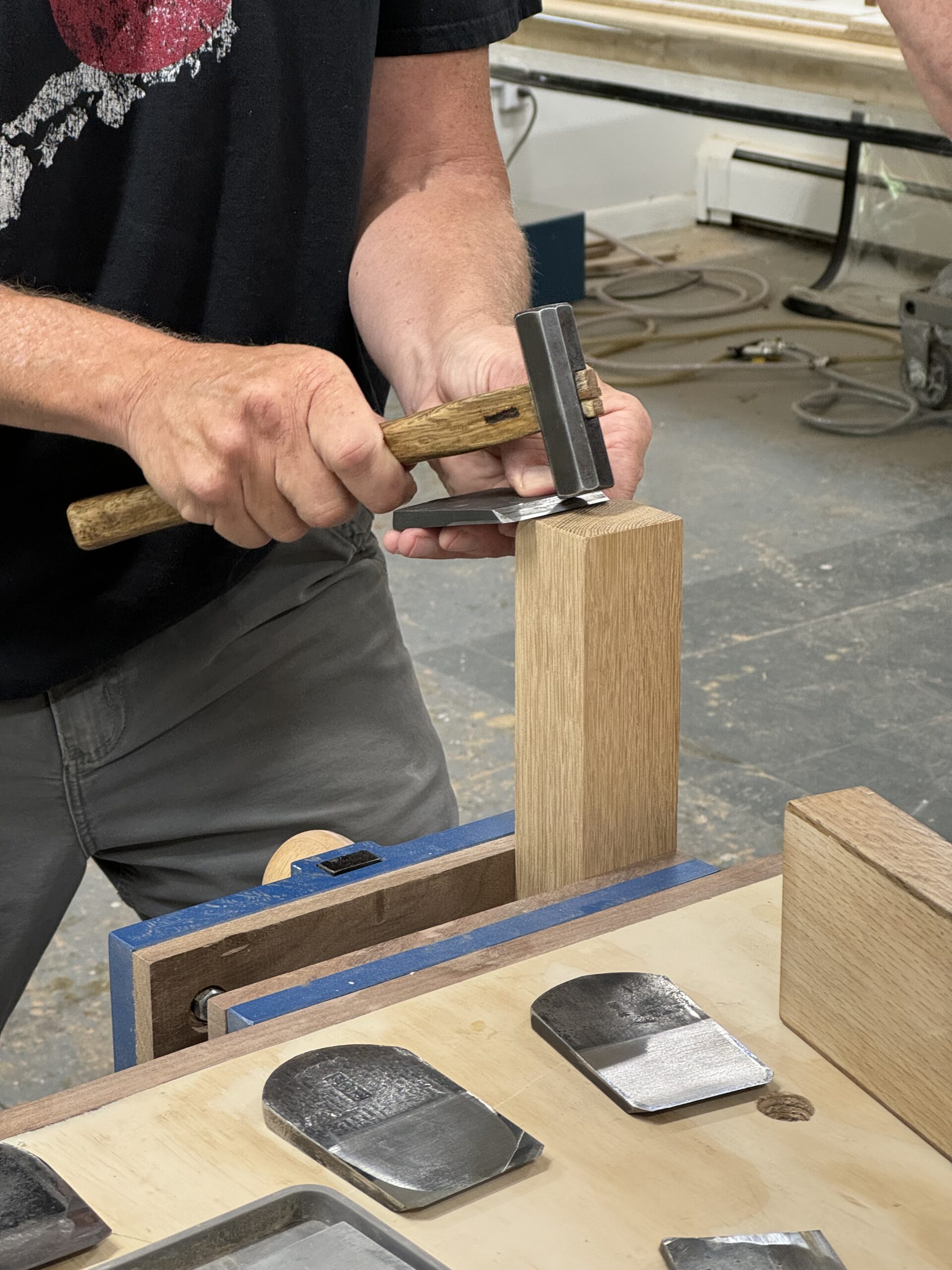 A photo of someone tapping out a handplane blade gently with a Japanese hammer. 