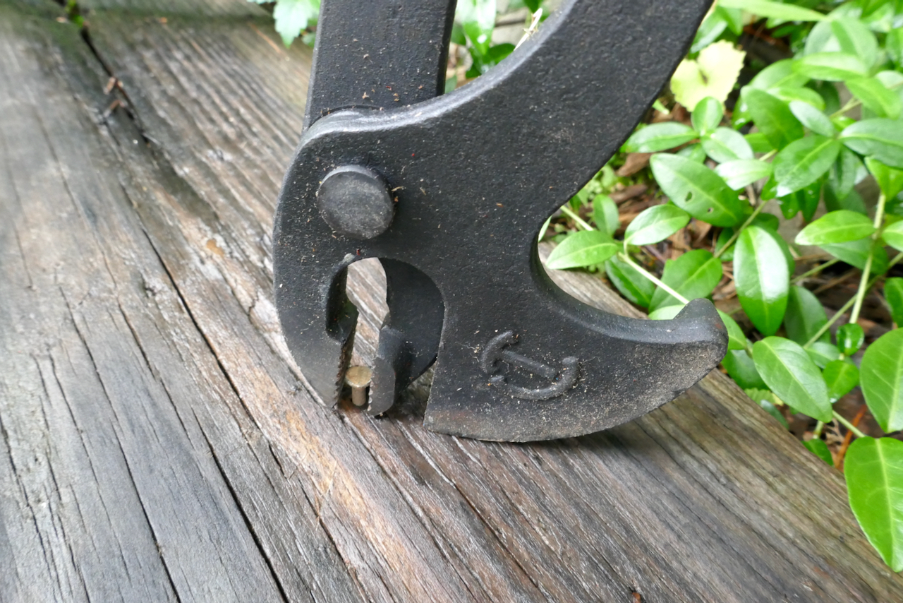 Pliers extracting a nail from a reclaimed board.